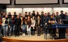 A group of students smiling in front of a whiteboard in a Yale SOM classroom.